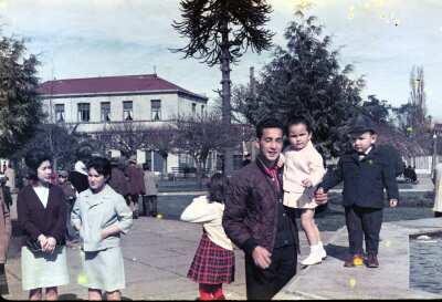 Retrato plano americano de Hombre con niña en brazos y niño de temprana edad de pie en pileta de agua en plaza de la Concordia de La Unión