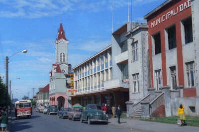 plano general de calle Prat. Se puede observar una fila de autos estacionados en el frontis de la municipalidad y también la parroquia San José en el fondo