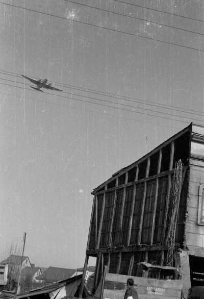 Plano general de avión sobrevolando casas derrumbadas por terremoto del 60', Valdivia.