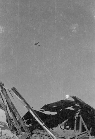 Plano entero de avión sobrevolando infraestructura derrumbada por el terremoto del 60', Valdivia