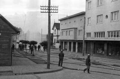 Plano entero de un grupo de bomberos realizando un procedimiento de entrenamiento a lo largo de una calle pavimentada ubicada en la ciudad de La Unión