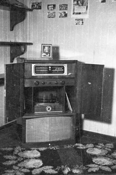 Plano entero de una radio con vinilo en el interior de la sala de una casa