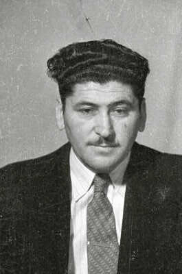 Retrato de estudio de Plano medio de un hombre de Traje posando de frente. Lleva puesto un pasador en la corbata