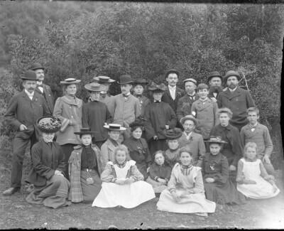 Plano general de un grupo de personas entre adultos y niños, posando para el retrato en un entorno natural